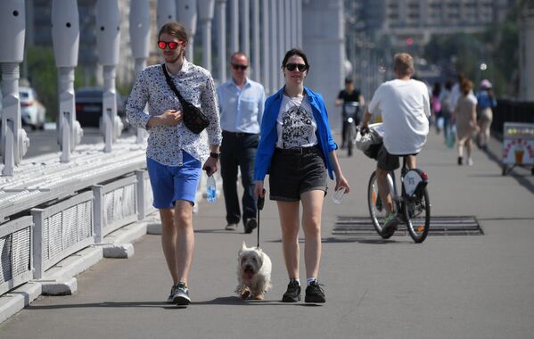 Молодые люди идут по Крымском мосту в Москве