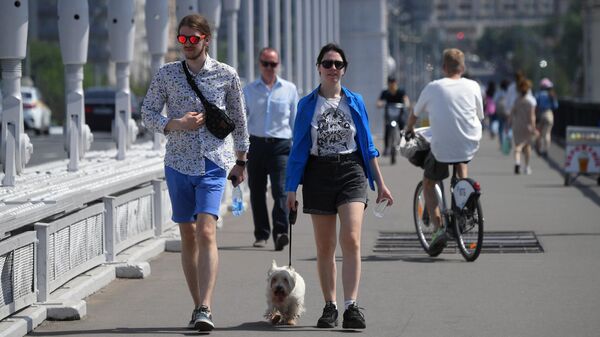 Молодые люди идут по Крымском мосту в Москве