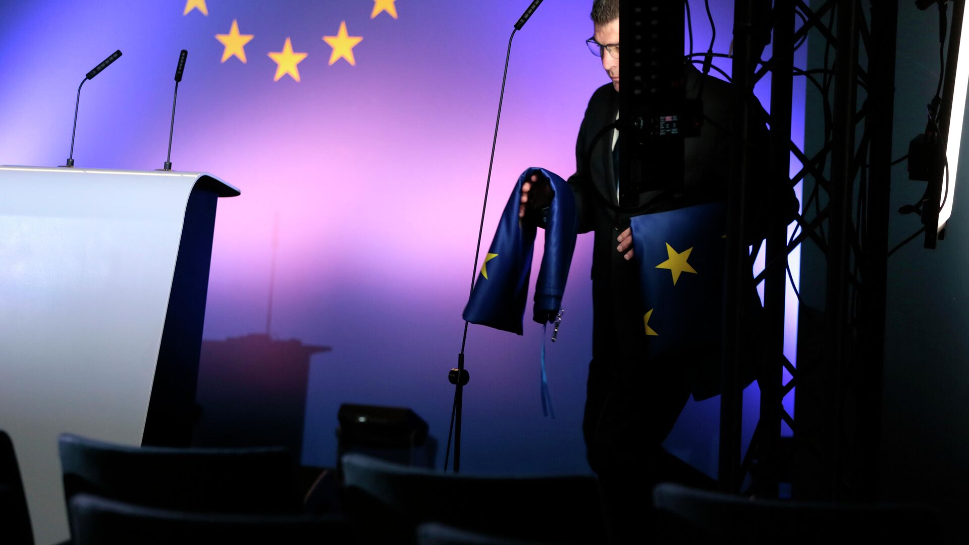 Сотрудник службы протокола с флагами ЕС в штаб-квартире Евросоюза в Брюсселе - РИА Новости, 1920, 15.03.2022