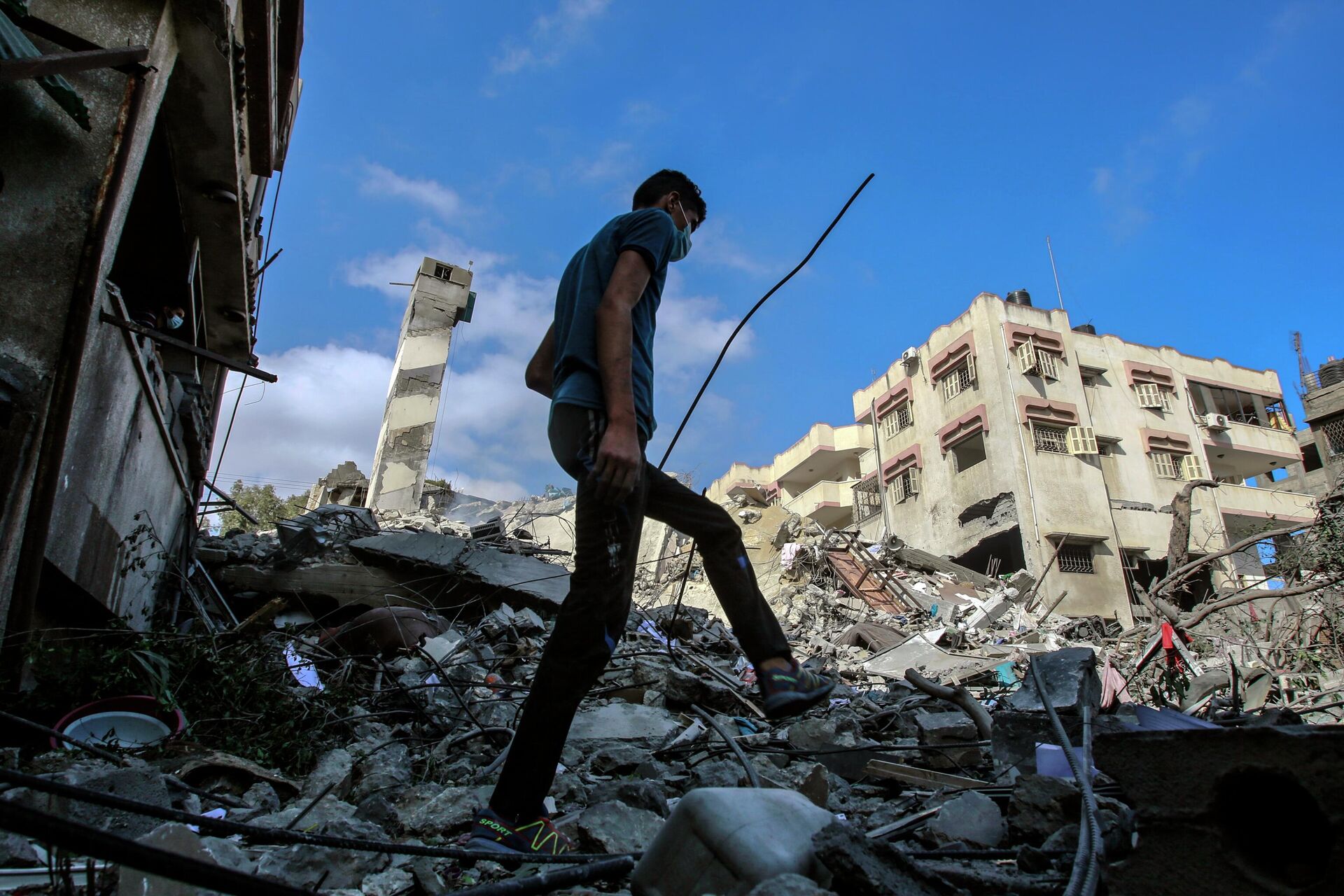 Молодой человек на месте разрушенных в результате бомбардировки зданий в секторе Газа - РИА Новости, 1920, 19.05.2021