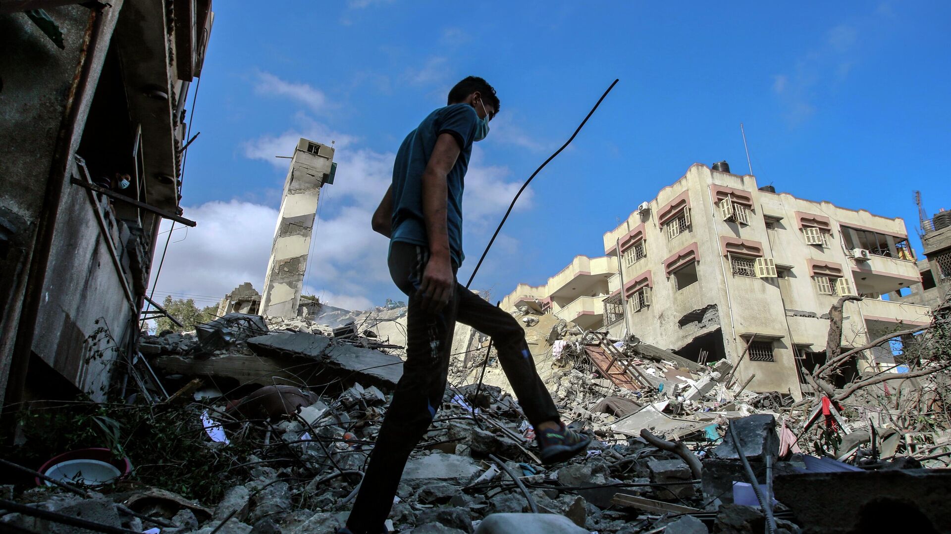 Молодой человек на месте разрушенных в результате бомбардировки зданий в секторе Газа. Архивное фото - РИА Новости, 1920, 08.12.2023