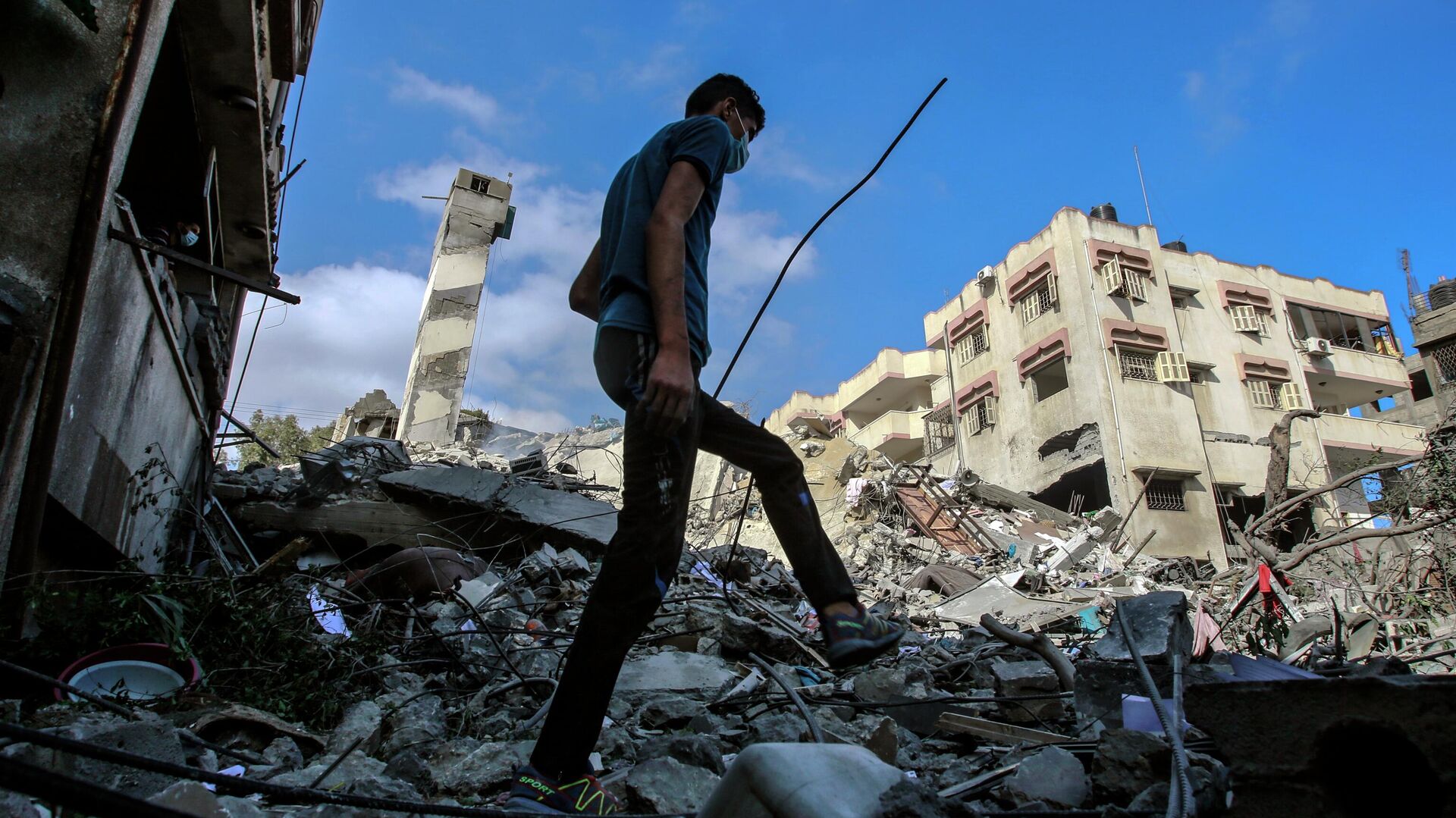 Молодой человек на месте разрушенных в результате бомбардировки зданий в секторе Газа - РИА Новости, 1920, 11.07.2021