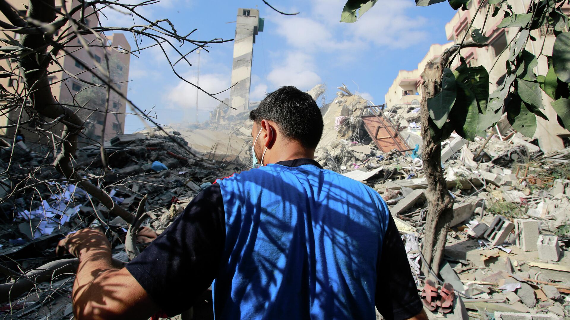 Молодой человек на месте разрушенных в результате бомбардировки зданий в секторе Газа - РИА Новости, 1920, 21.05.2021