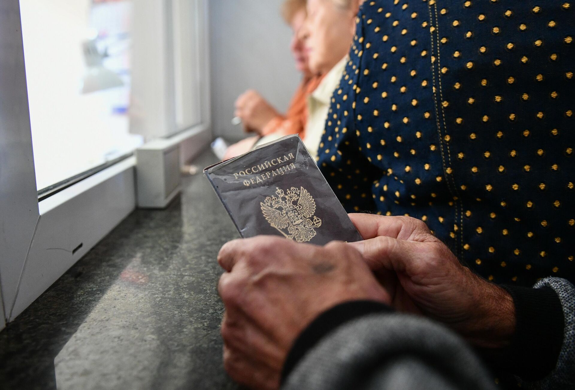 Пассажир держит в руках паспорт на железнодорожном вокзале - РИА Новости, 1920, 19.05.2021