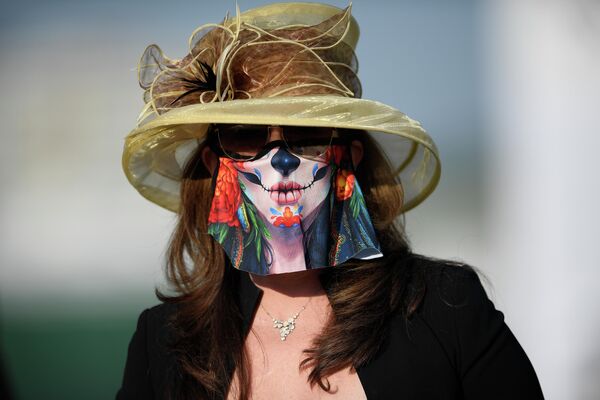 Женщина в защитной маске на скачках Preakness Stakes в Балтиморе 