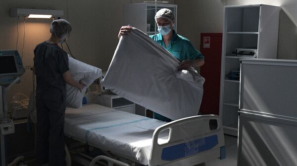 Медицинские работнике застилают кровати в отделении реанимации и интенсивной терапии в госпитале Ленэкспо в Санкт-Петербурге