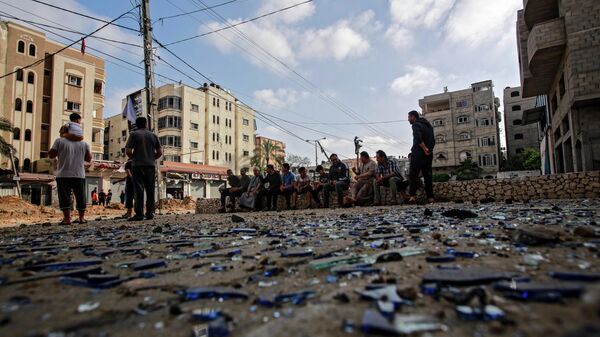 Жители Газы на улице, поврежденной в результате бомбардировки. Архивное фото