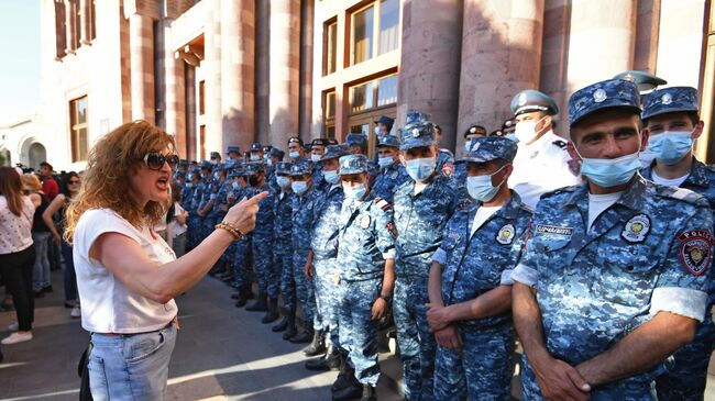 Участница акции с требованием опубликовать договор с Азербайджаном и сотрудники полиции во время протеста в Ереване