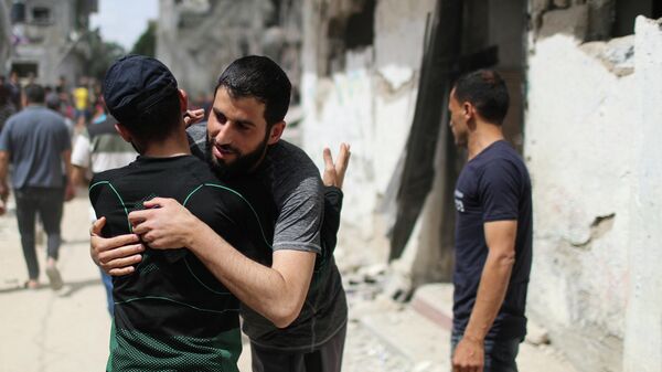 Палестинцы обнимаются после возвращения в свои разрушенные дома в Бейт-Хануне на севере сектора Газа