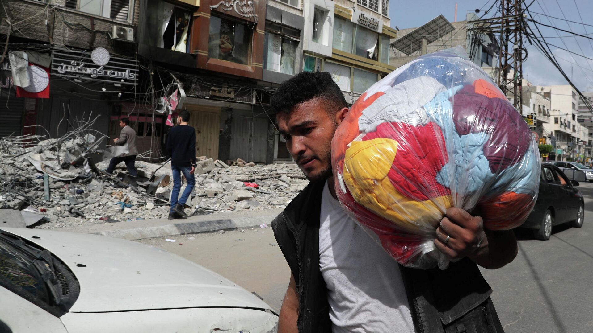 Палестинец проходит мимо разрушенных в результате бомбардировки зданий в секторе Газа, после объявления о прекращении огня между Израилем и ХАМАС - РИА Новости, 1920, 21.05.2021