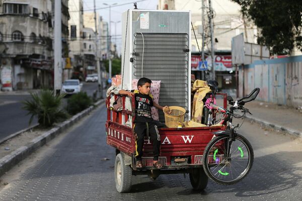 Палестинский мальчик возвращается домой после объявления о прекращении огня между Израилем и ХАМАС