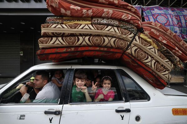 Палестинская семья возвращается домой в городе Газа после объявления о прекращении огня между Израилем и ХАМАС