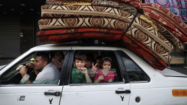 Палестинская семья возвращается домой в городе Газа после объявления о прекращении огня между Израилем и ХАМАС