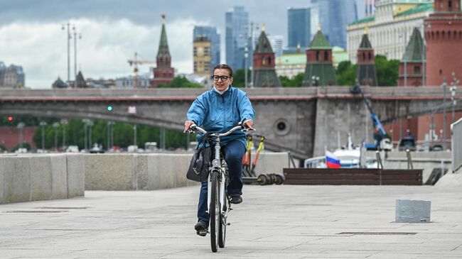 Девушка едет на велосипеде по Москворецкой набережной в Москве