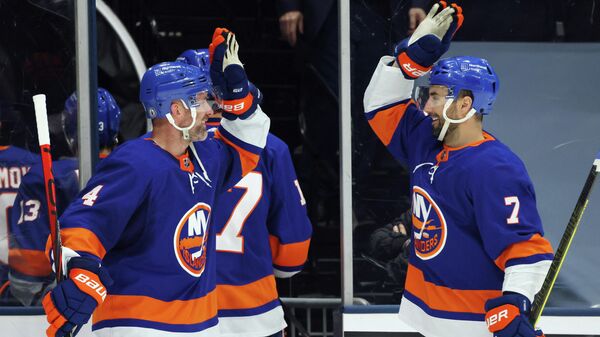 UNIONDALE, NEW YORK - MAY 22: Andy Greene #4 and Jordan Eberle #7 of the New York Islanders celebrate a 4-1 win over the Pittsburgh Penguins in Game Four of the First Round of the 2021 Stanley Cup Playoffs at the Nassau Coliseum on May 22, 2021 in Uniondale, New York.   Bruce Bennett/Getty Images/AFP (Photo by BRUCE BENNETT / GETTY IMAGES NORTH AMERICA / Getty Images via AFP)