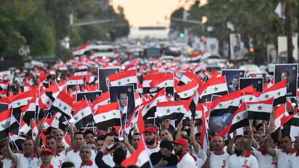 Участники акции в поддержку президента Сирии Башара Асада в Дамаске