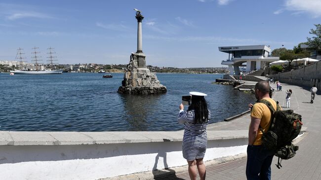 Девушка фотографирует памятник затопленным кораблям в Севастополе