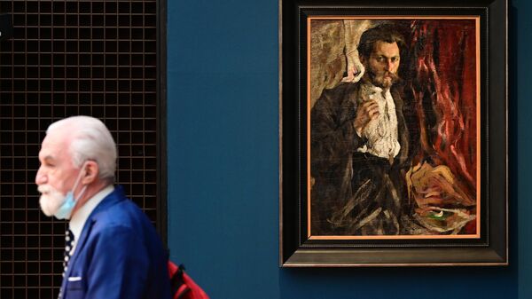 Мужчина возле картины Портрет Г. А. Слобожаникова на выставке работ художника Николая Фешина в Третьяковской галерее в Москве