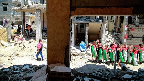 Дети у дома, разрушенного в результате бомбардировки на северо-востоке сектора Газа в городе Бейт-Ханун