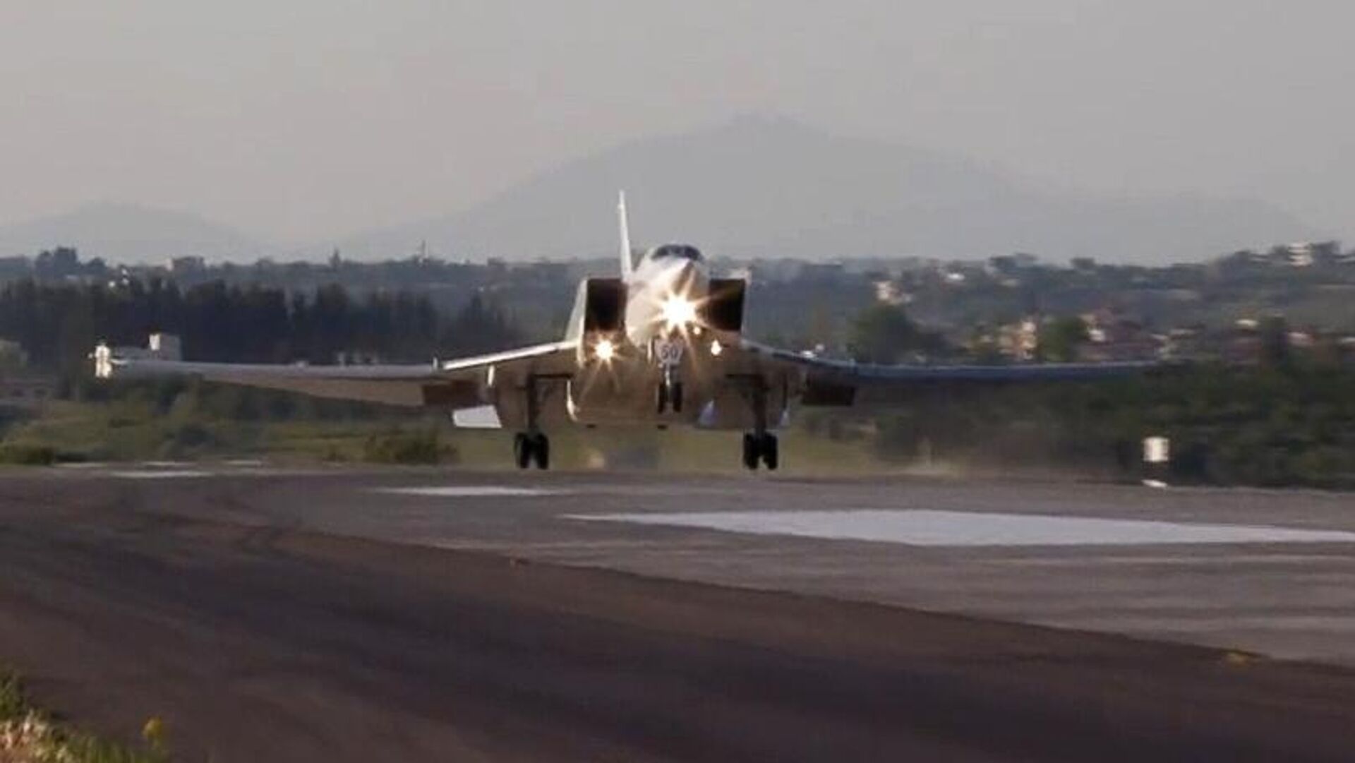 Дальний бомбардировщик Ту-22М3 совершает посадку на авиабазе Хмеймим в Сирии. Кадр видео - РИА Новости, 1920, 25.05.2021