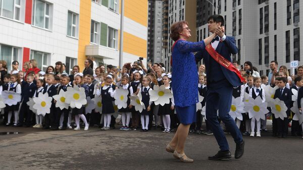Выпускник танцует с учительницей во время последнего звонка в многопрофильной школе №181 в Казани