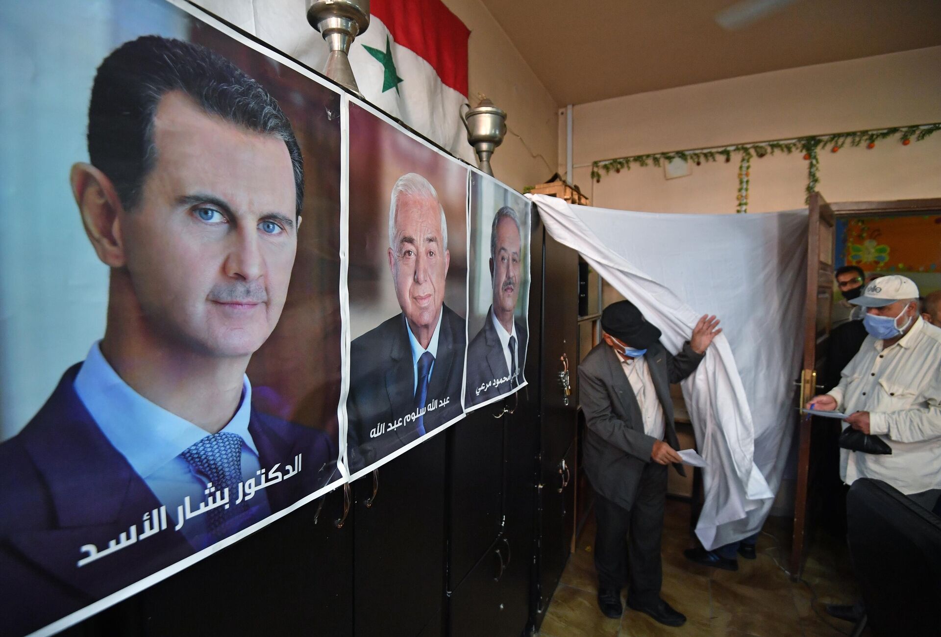 Плакат с кандидатами на одном из избирательных участков Дамаска, где проходит голосование на выборах президента Сирии - РИА Новости, 1920, 27.05.2021