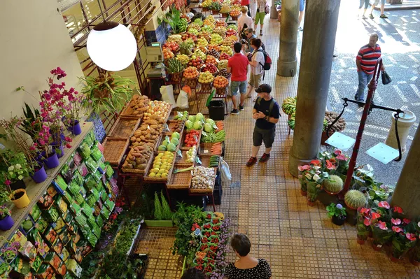 Лотки с фруктами на муниципальном фермерском рынке Меркадо дош Лаврадореш в городе Фуншал на острове Мадейр