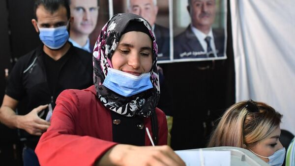 Женщина голосует на выборах президента Сирии на одном из избирательных участков Дамаска