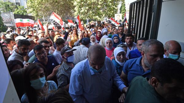 Люди возле одного из избирательных участков Дамаска, где проходит голосование на выборах президента Сирии