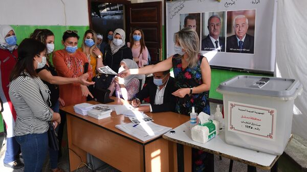 Люди на одном из избирательных участков Дамаска, где проходят на выборы президента Сирии