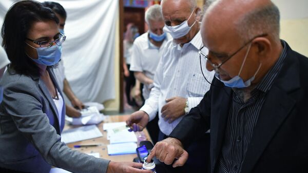 Мужчина сдает отпечатки пальцев для принятия участия в голосовании на выборах президента Сирии на одном из избирательных участков Дамаска
