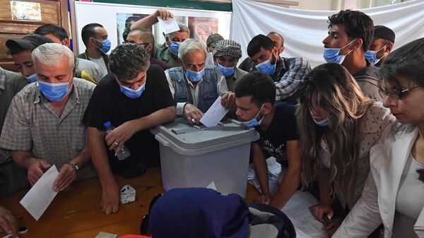 Люди голосуют на выборах президента Сирии на одном из избирательных участков Дамаска