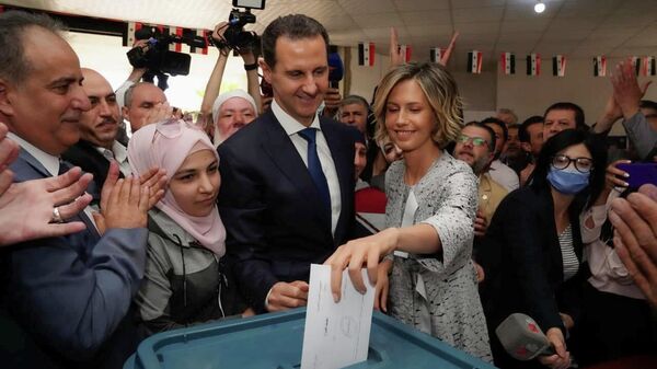 Асма Асад опускает бюллетень в урну во время выборов президента Сирии