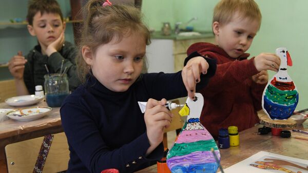 Дети раскрашивают фигурки деревянных гусей