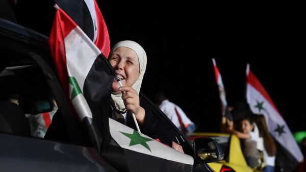 Женщина радуется победе на президентских выборах Башара Асада в Дамаске