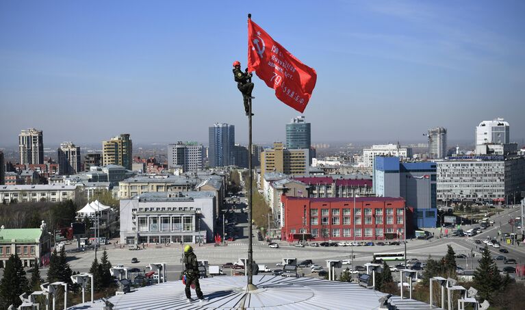 Промышленные альпинисты во время установки копии Знамени Победы над куполом Новосибирского театра оперы и балета (НОВАТ) в центре Новосибирска 