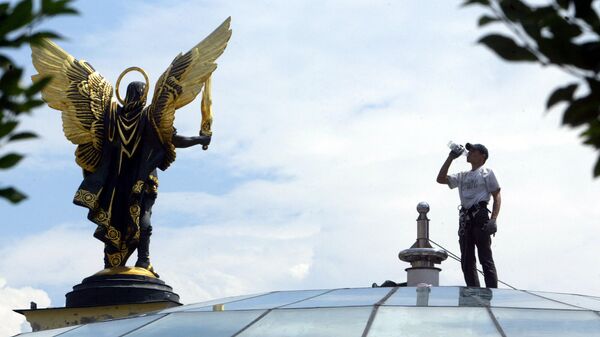 Рабочий на куполе здания возле памятника Архангелу Михаилу, Киев
