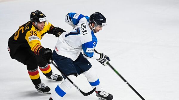 Слева направо: Фредерик Тиффельс (Германия) и Оливер Каски (Финляндия) в матче группового этапа чемпионата мира по хоккею 2021 между сборными командами Германии и Финляндии.