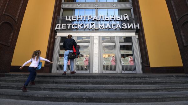 Женщина с ребенком идет в Центральный детский магазин в Москве
