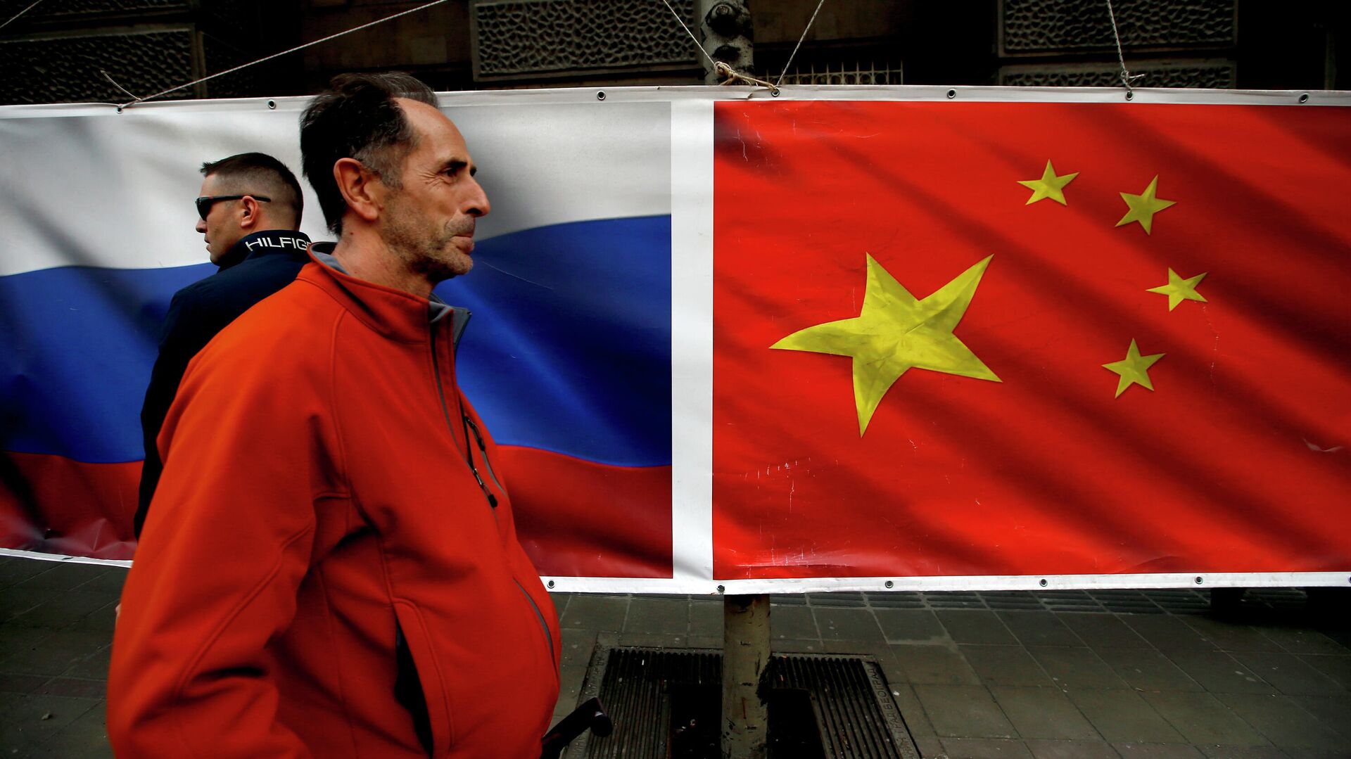 Люди проходят мимо баннера с флагами России и Китая - РИА Новости, 1920, 02.03.2022