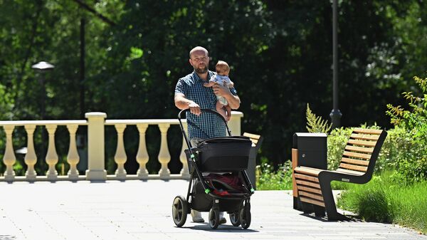 Мужчина гуляет с ребенком в парке Сад будущего в Москве