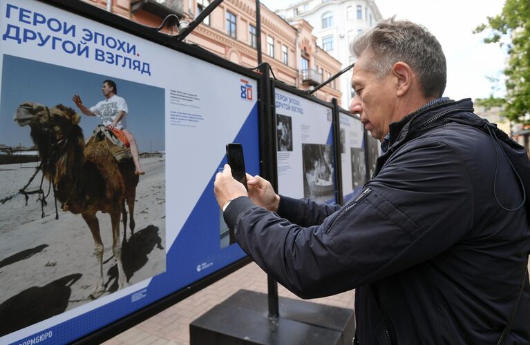 Мужчина на фотовыставке Герой эпохи. Другой взгляд международной медиагруппы Россия сегодня на улице Старый Арбат в Москве