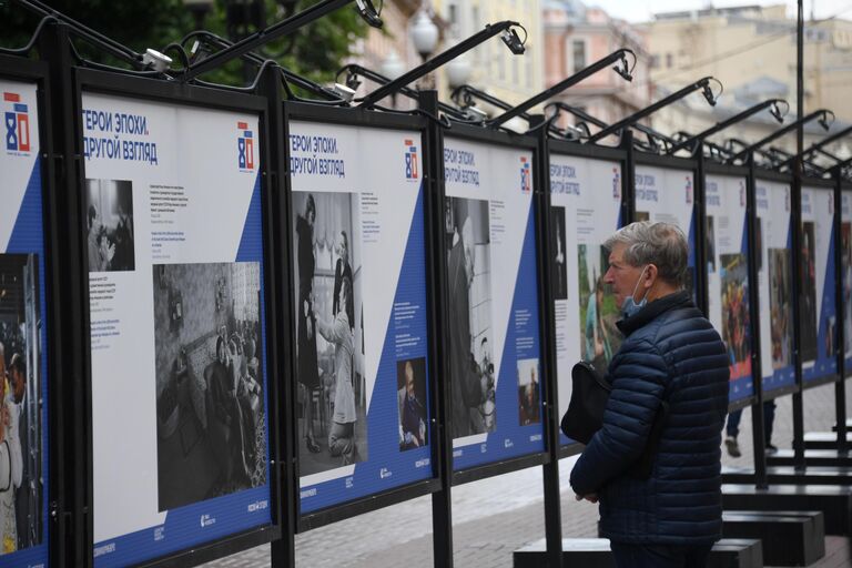 Мужчина на фотовыставке Герой эпохи. Другой взгляд международной медиагруппы Россия сегодня на улице Старый Арбат в Москве