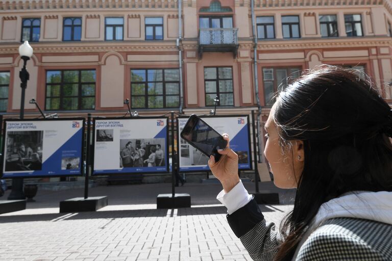 Девушка на фотовыставке Герой эпохи. Другой взгляд международной медиагруппы Россия сегодня на улице Старый Арбат в Москве