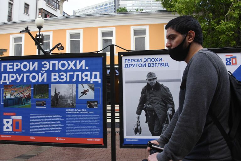 Молодой человек на фотовыставке Герой эпохи. Другой взгляд международной медиагруппы Россия сегодня на улице Старый Арбат в Москве