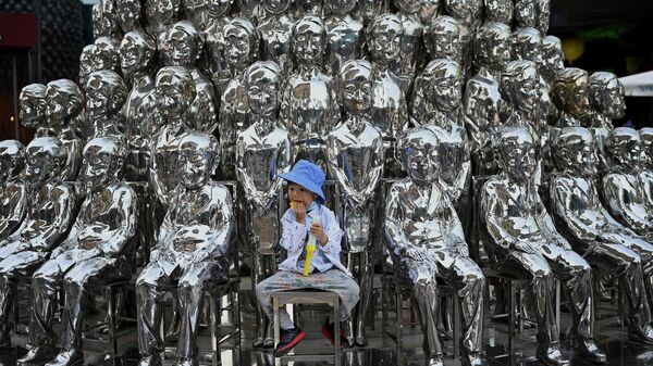 Мальчик на фоне инсталляции в Пекине, Китай 