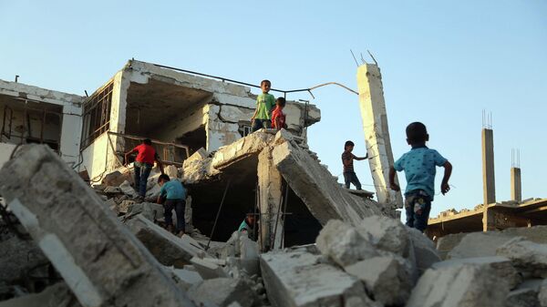 Сирийские дети играют среди обломков зданий в восточной части региона Гута