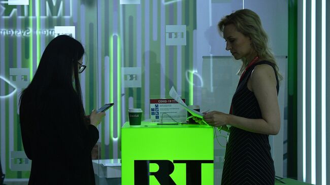 Девушки на стенде телеканала RT на Петербургском международном экономическом форуме- 2021 в конгрессно-выставочном центре Экспофорум