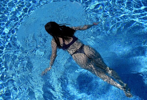 Девушка плавает в открытом бассейне в фанпарке Бобровый лог в Красноярске