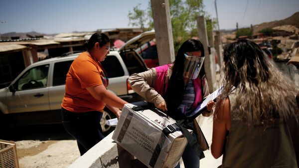 Сотрудник избирательного участка несет ящик с бланками для голосования, Мексика